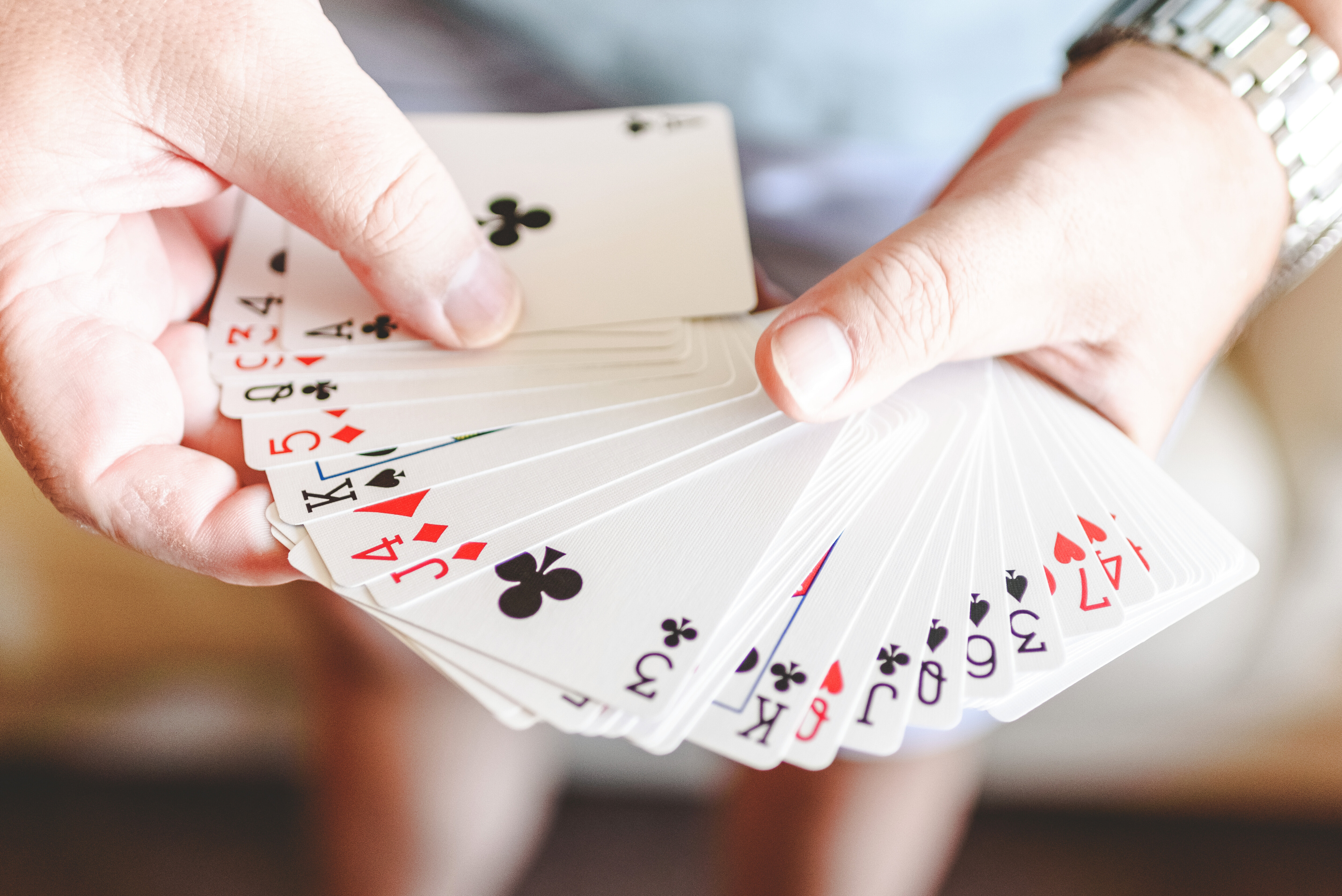  Hands Doing Magic Trick with Playing Cards.